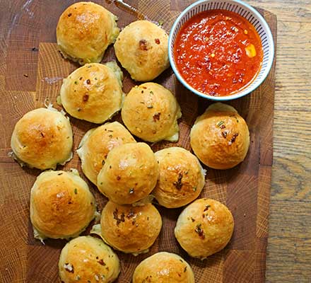 Cheese-stuffed garlic dough balls with a tomato sauce dip