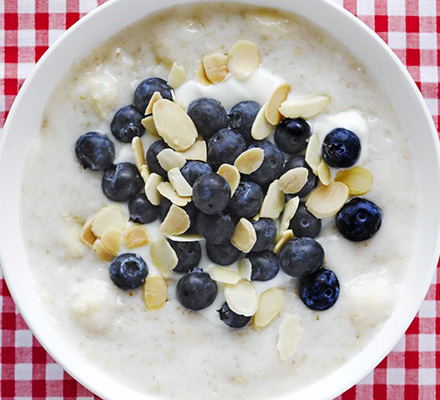 Creamy yogurt porridge with banana, blueberry & almond topping