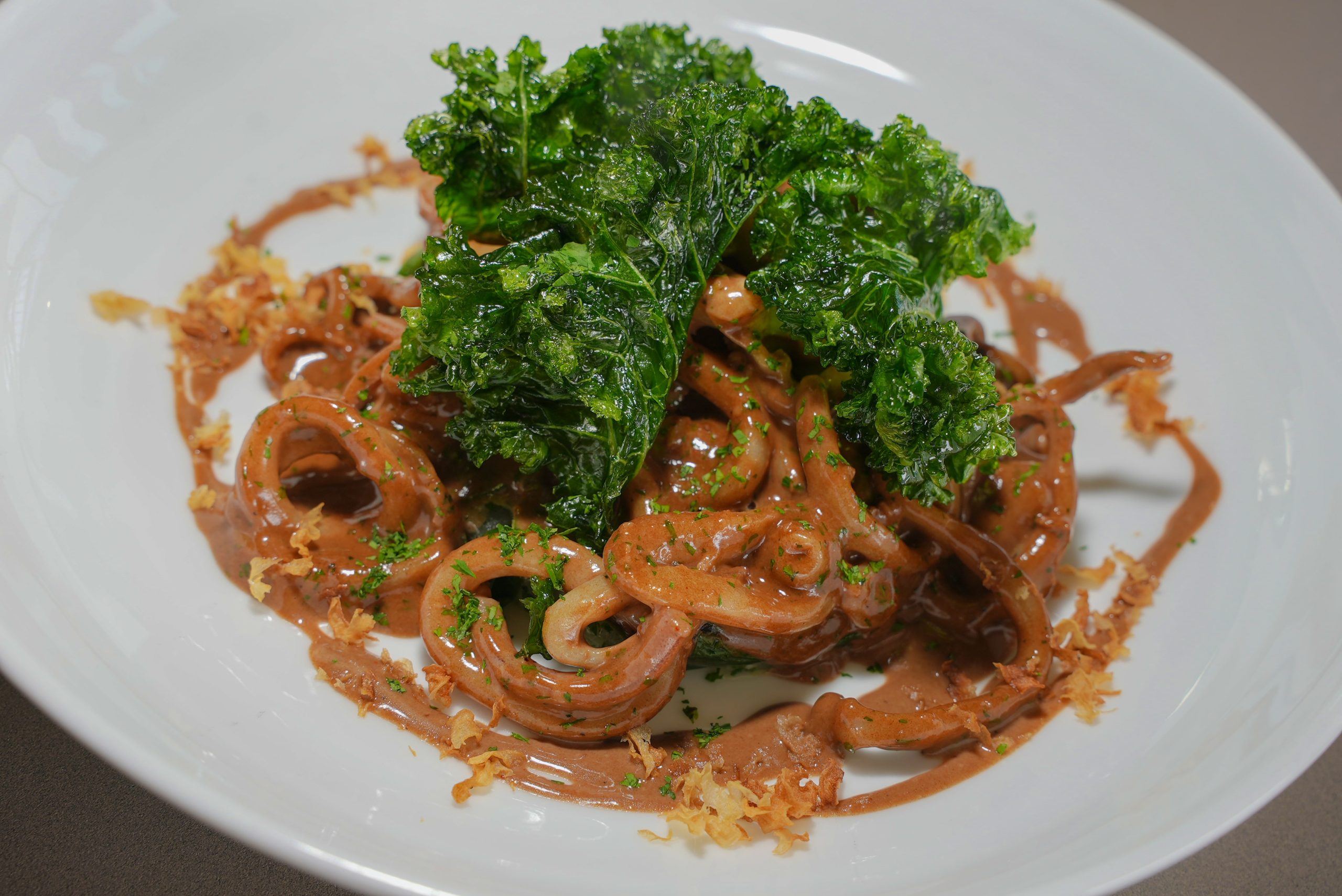 Pan-fried squid rings with black garlic butter sauce and Swiss chard-min